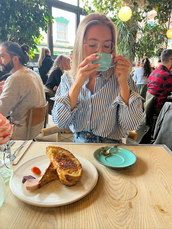 Megan sipping coffee in a café