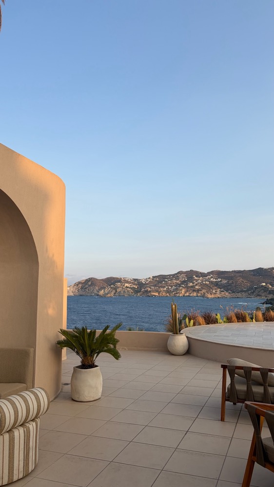 Sunlit terrace looking out over the sea and hills