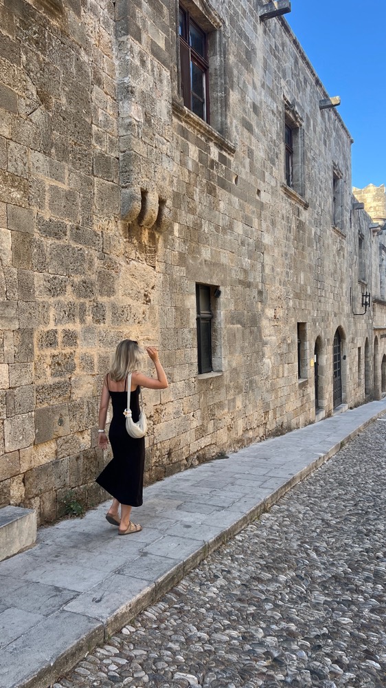 Megan walking along a stone street in Rhodes old town